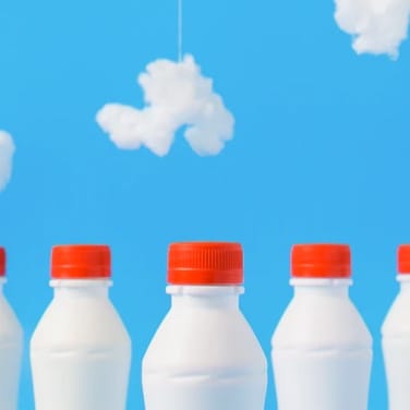 Five milk bottles on blue background